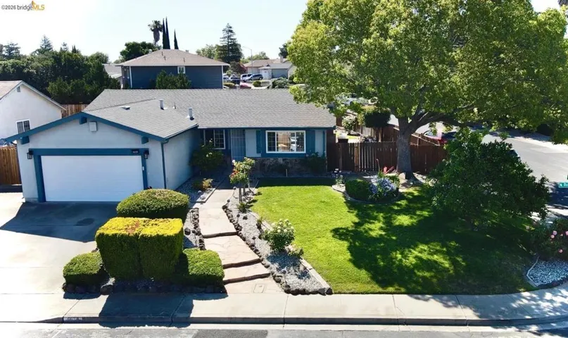 Single-story residence featuring a two-car garage, a stone walkway, and a manicured front lawn