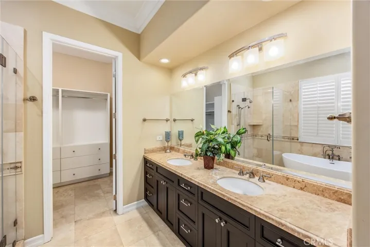 Spacious primary bathroom featuring a dual-sink vanity, generous storage, and direct access to the walk-in closet