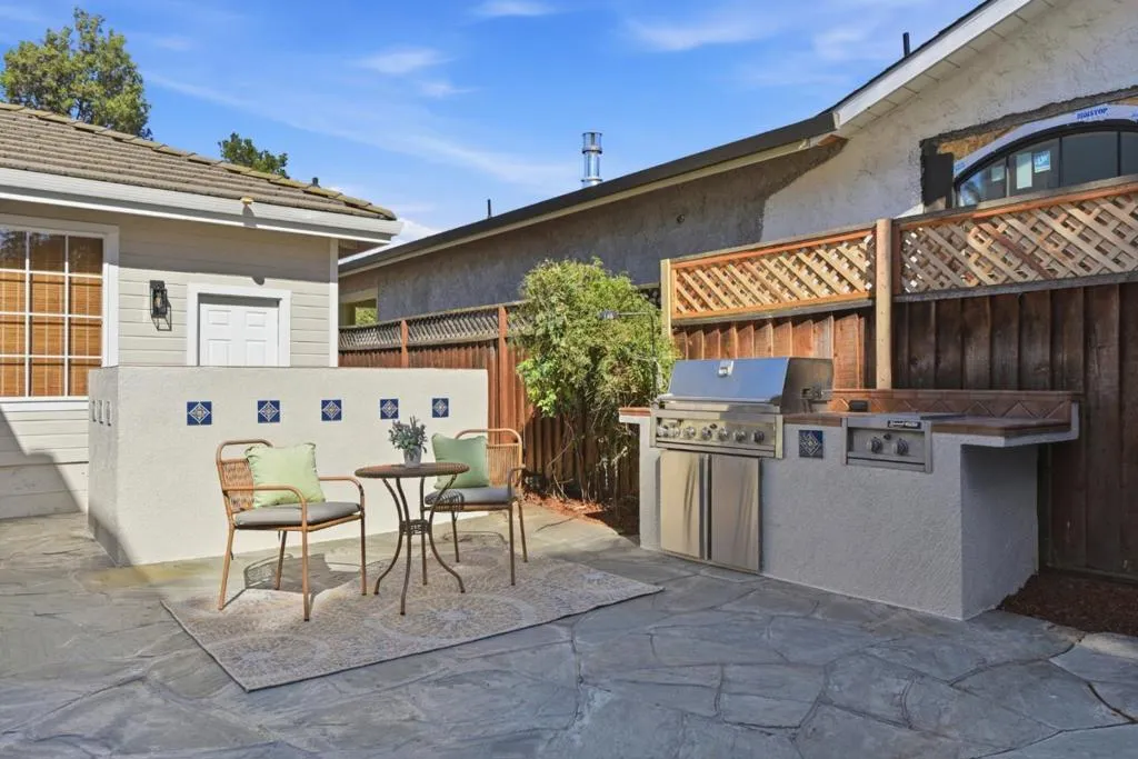 Outdoor dining space with flagstone and BBQ area.