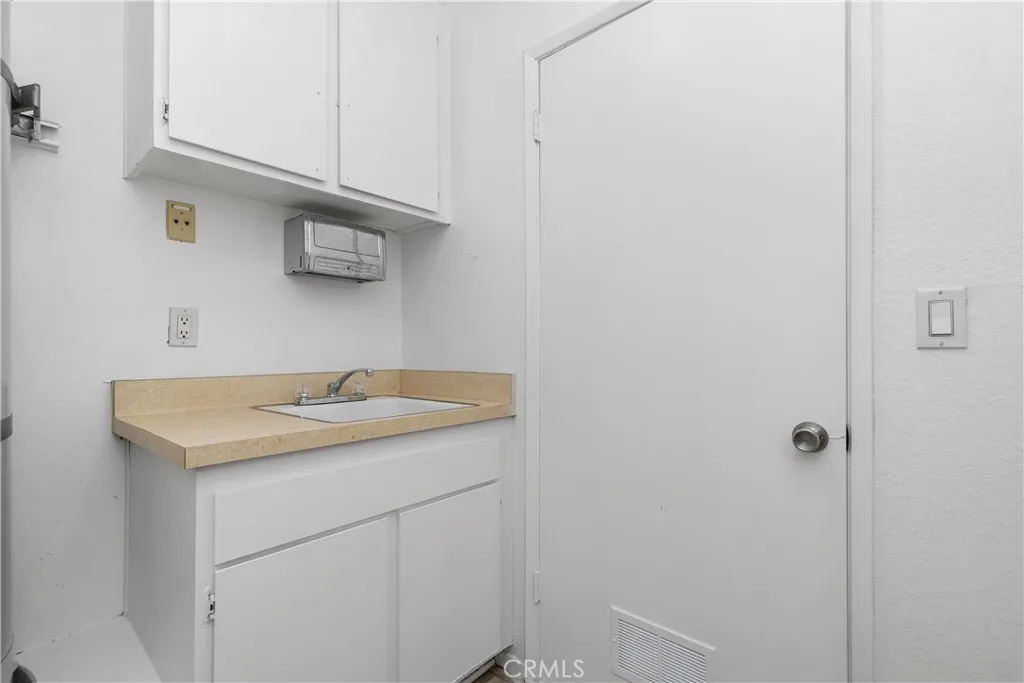 Laundry room with sink and storage