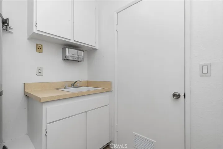 Laundry room with sink and storage