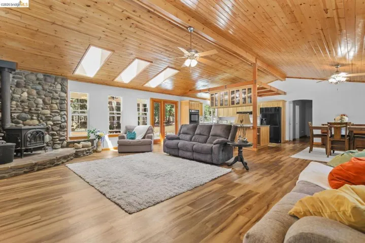 Expansive living area with wood-finish flooring and a wood plank ceiling