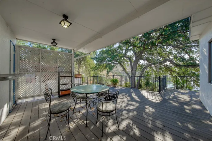 back covered deck off kitchen and back living room with stairs to go below to garage and yard