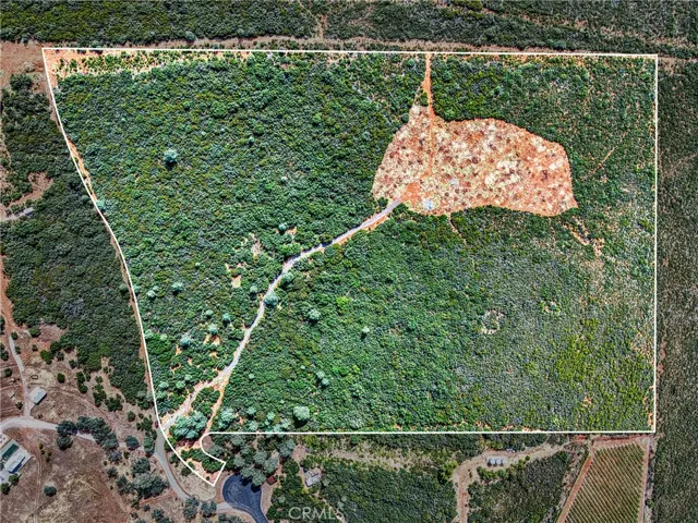Areal view of the property showing the road onto the property and the top with some clearing done...