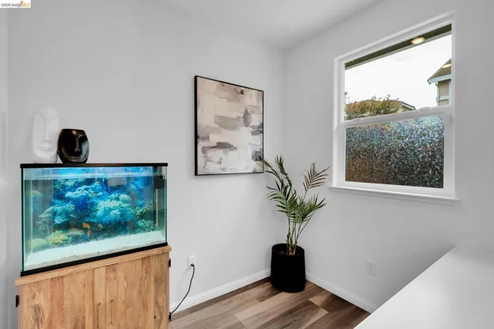 Bright interior space featuring wood-finish flooring and a single-pane window with privacy film