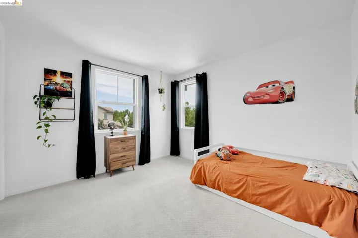 Bright room featuring light-toned carpeting and white walls