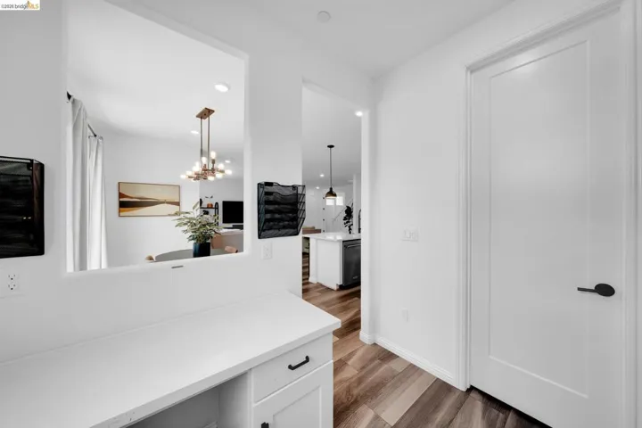 Built-in desk area with white cabinetry and dark hardware