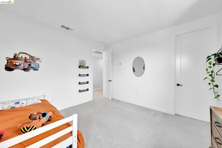 Spacious interior room with light-colored carpeting and white walls