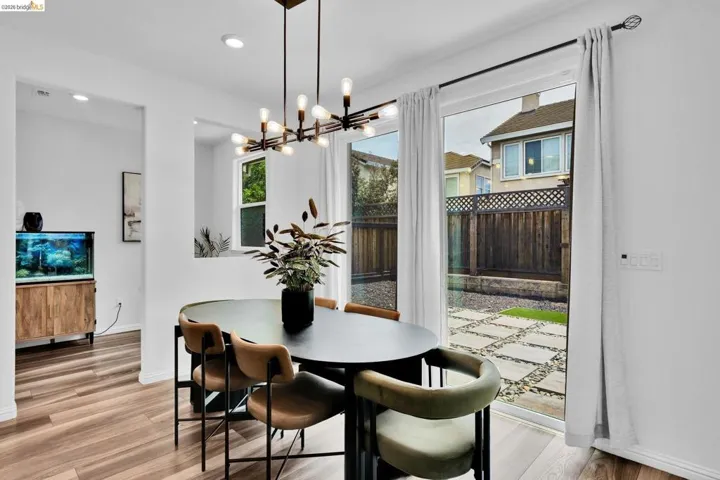 Dining area featuring wood-finish flooring, recessed lighting, and a contemporary linear chandelier