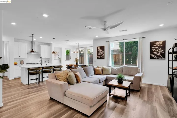 Open-concept living space featuring wood-finish flooring, recessed lighting, and a contemporary ceiling fan