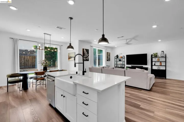 Open-concept living space featuring wood-finish flooring, recessed lighting, and a white ceiling fan