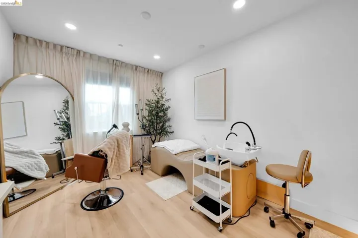 Bright room featuring light wood-finish flooring, white walls, and recessed lighting