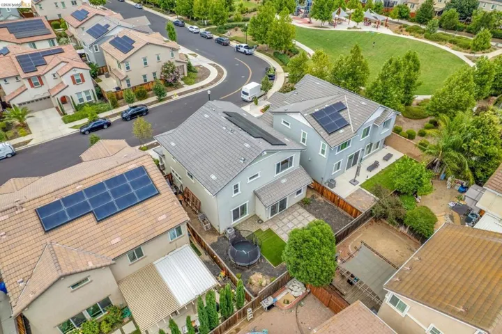 Aerial view highlighting a suburban neighborhood with residential properties featuring solar panel installations