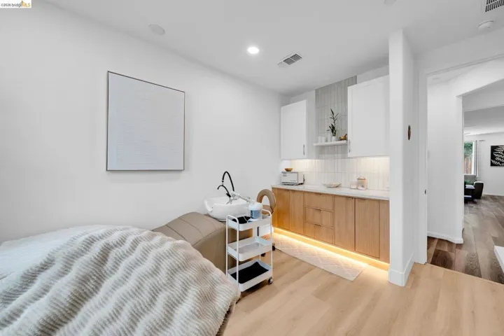 Bright room featuring light wood-finish flooring, recessed lighting, and a built-in cabinetry unit