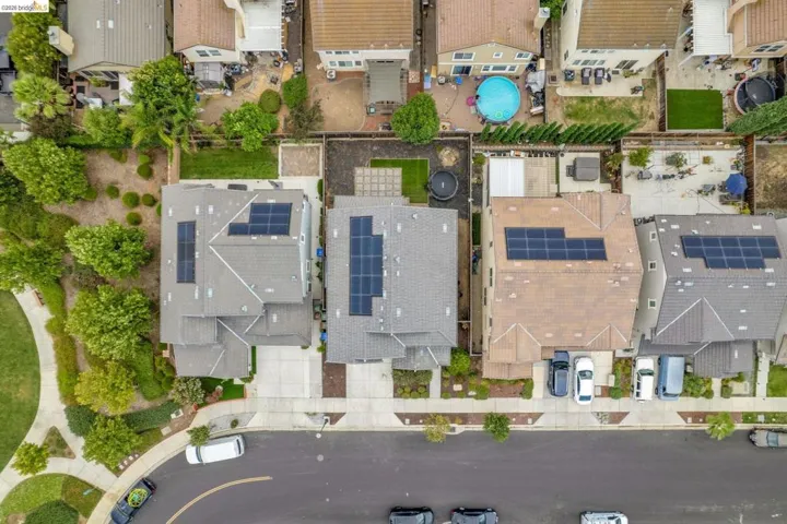 Aerial perspective showcasing a residential property with a gray shingle roof and solar panels