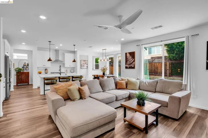 Open-concept living space featuring wood-finish flooring, recessed lighting, and a modern ceiling fan