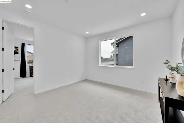 Spacious interior room with light-colored carpeting and white walls