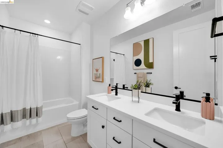 Contemporary bathroom featuring a double vanity with white cabinetry and integrated sinks