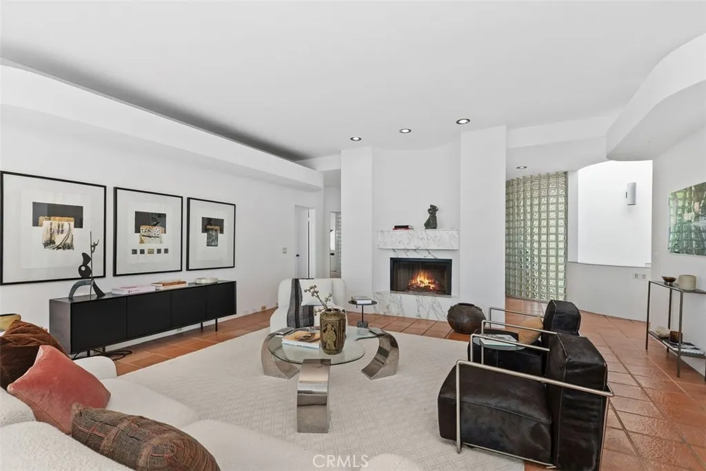 Living room with foyer behind fireplace, glass block walls are found in some spaces throughout the house.