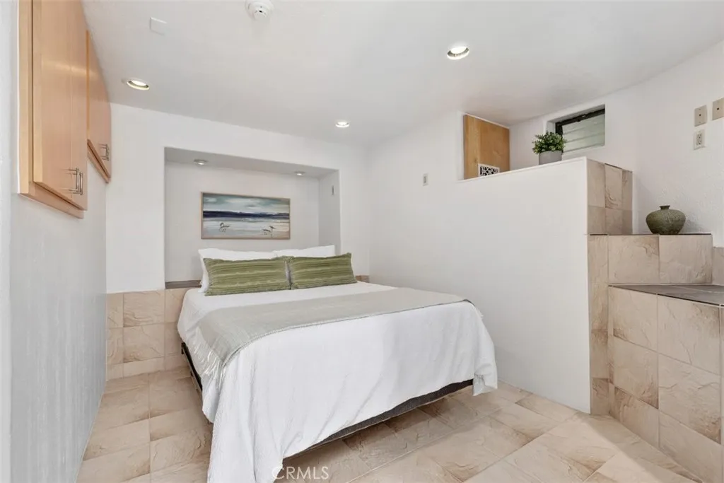Bedroom in guest quarters has cabinets, window to right, with ensuite bathroom.