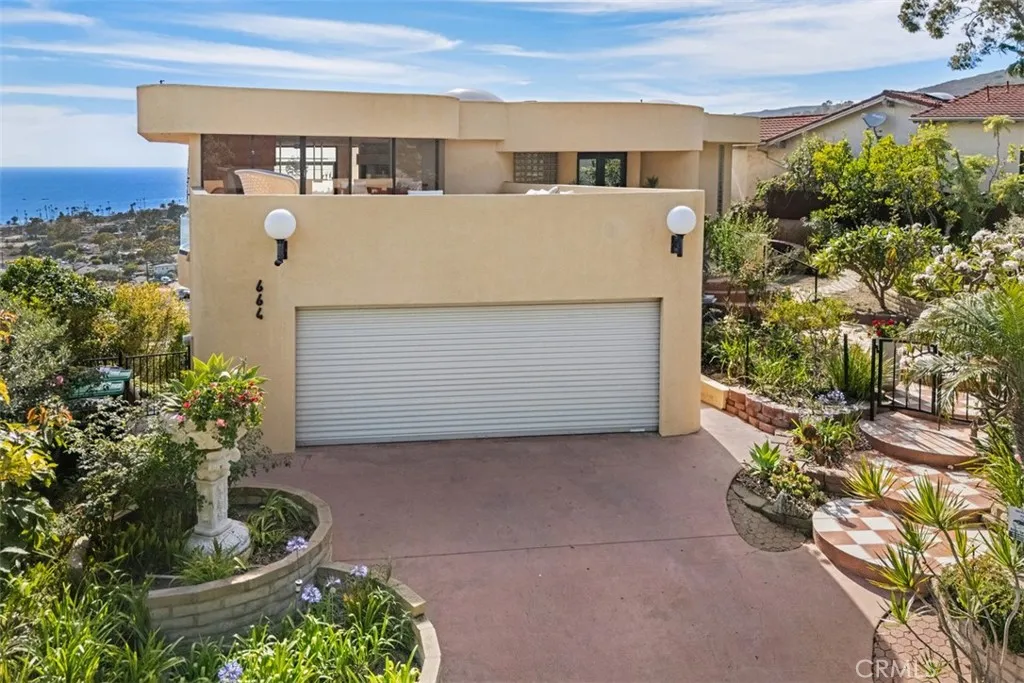 Two car attached garage with large open air deck above, resurfaced in recent years. Large commercial roll up garage door is fire-resistant metal material.