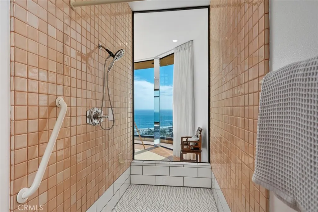 Primary bathroom has large shower, looks out towards view, has recently retiled base.