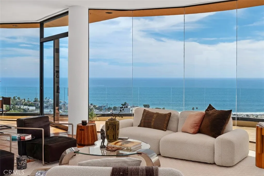 Deck with glass panels off living room is accessed by sliding glass door.