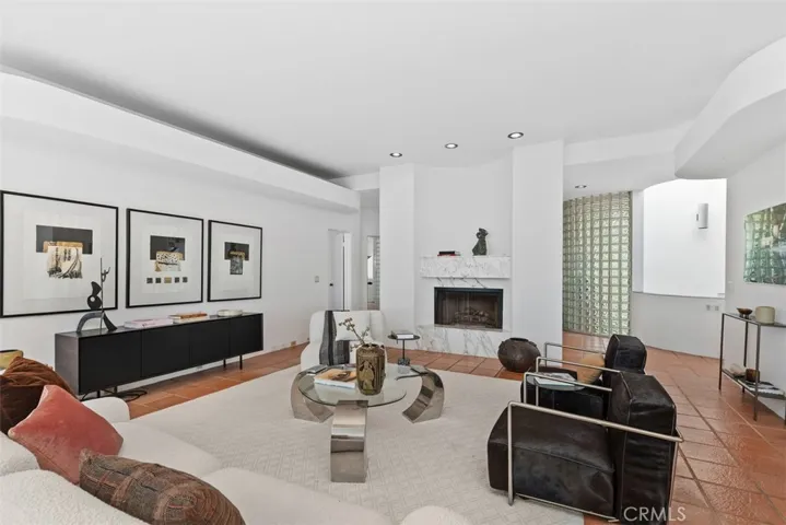 Living room has a centered marble  fireplace.