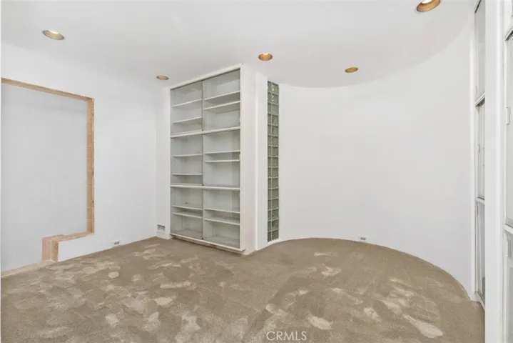 Bonus room on second level, could be library as has many shelves with glass doors.