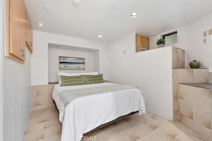 Bedroom in guest quarters has cabinets, window to right, with ensuite bathroom.