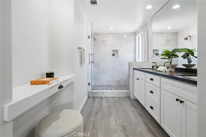 Beautifully remodeled primary bathroom with a dual-sink vanity and spacious walk-in shower