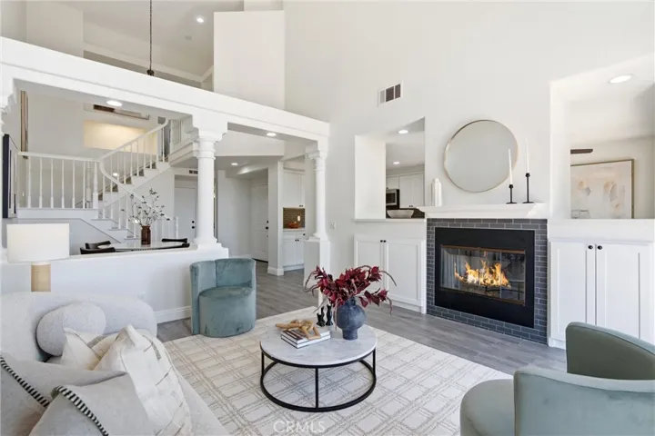 Soaring ceilings and a fireplace create an impressive living room setting