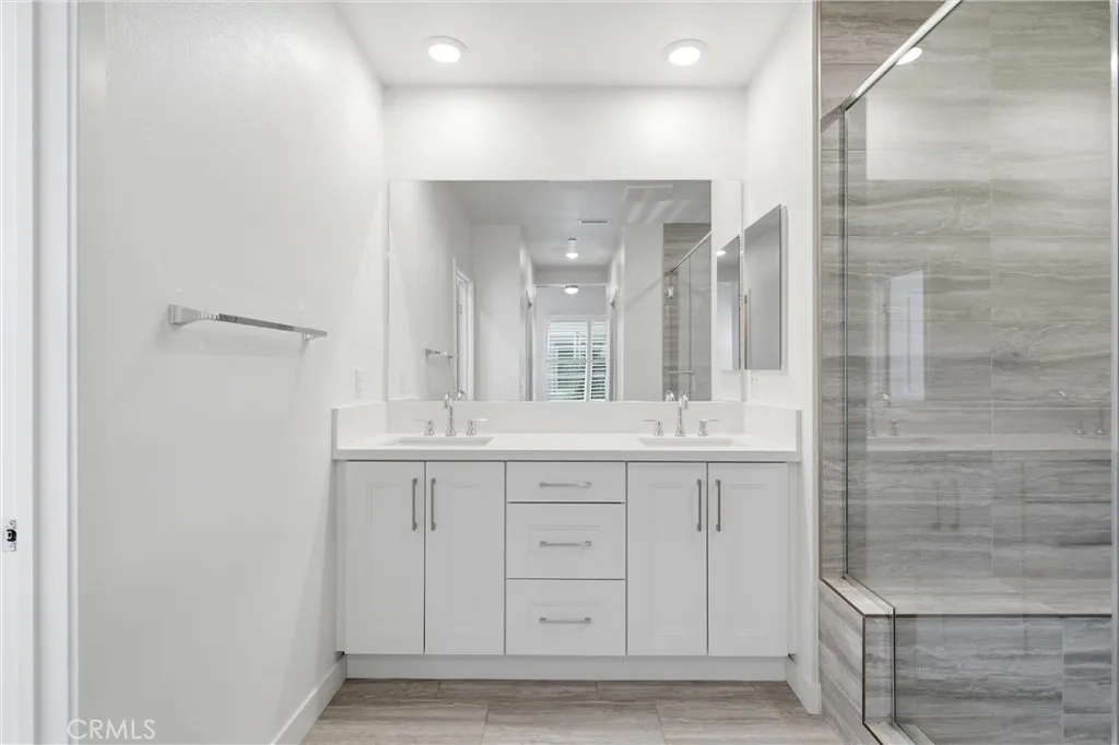 Spa-inspired primary bath with dual quartz vanities and generous storage.