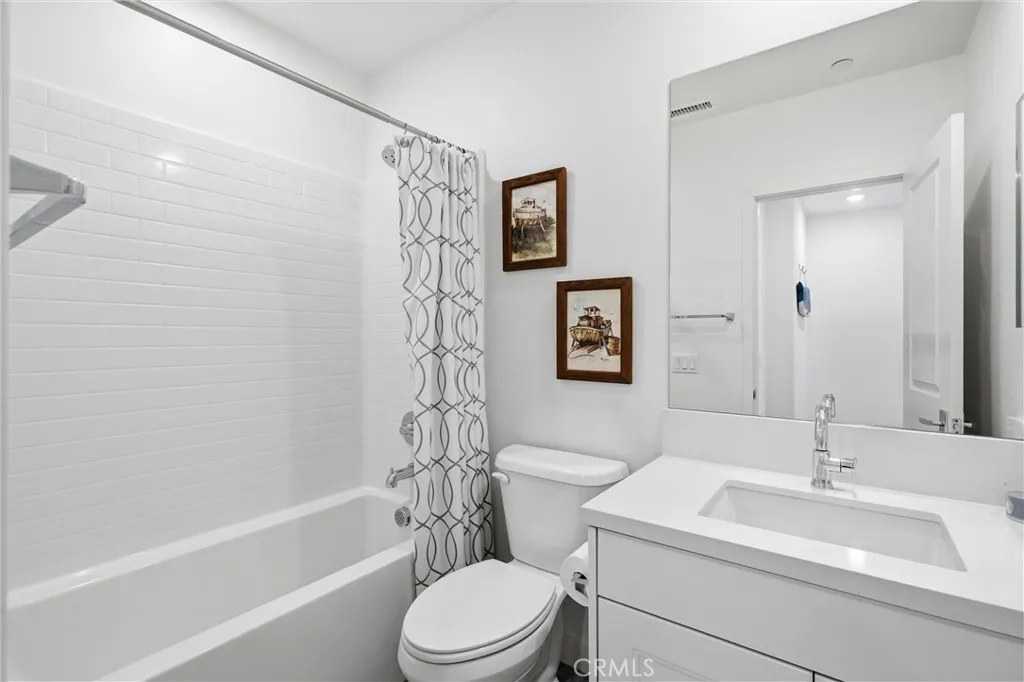 Beautifully appointed guest bathroom with quartz vanity and subway tile shower surround.