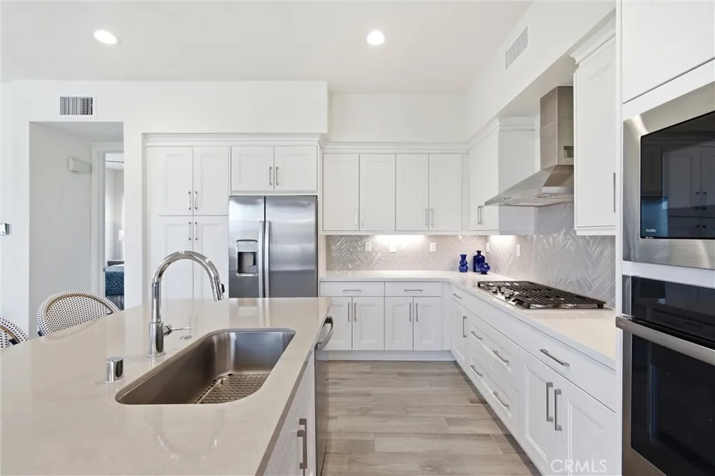Designer kitchen featuring quartz countertops, herringbone backsplash, and premium appliances.
