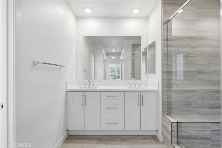Spa-inspired primary bath with dual quartz vanities and generous storage.
