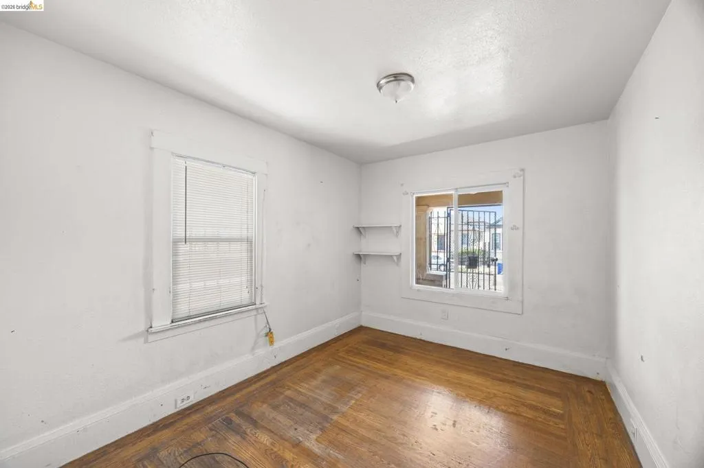 Wood-finish flooring with white baseboards and trim