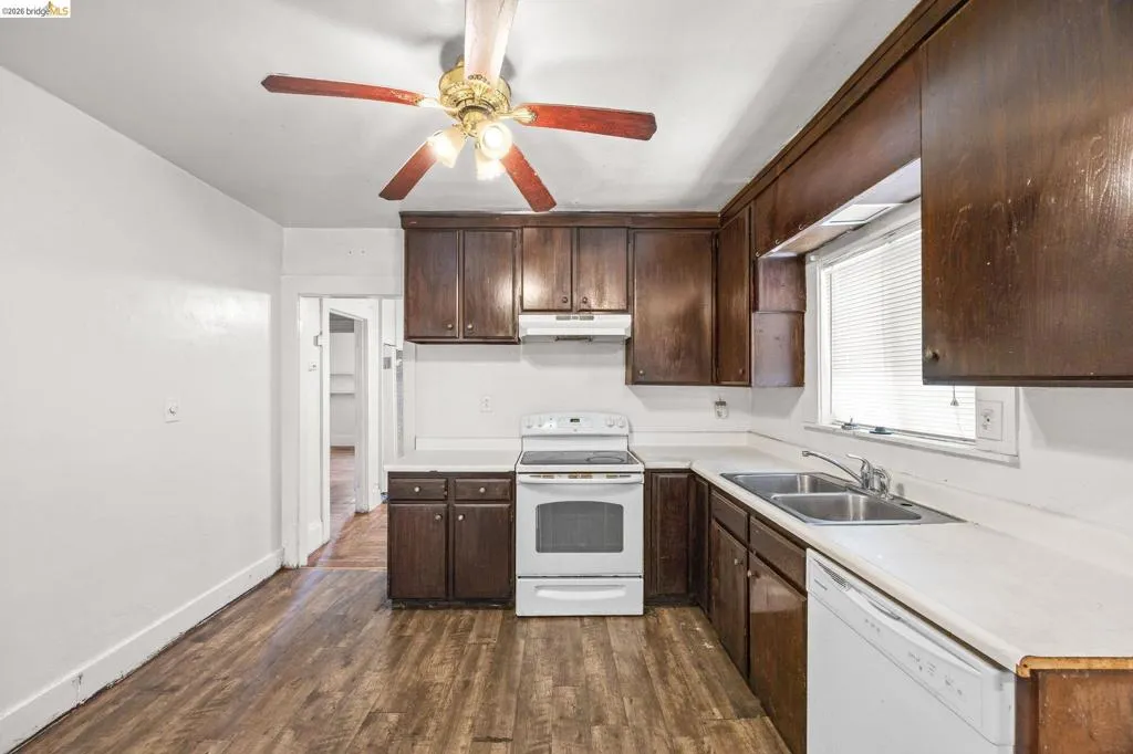 Kitchen featuring dark wood-finish cabinetry, white countertops, and wood-finish flooring