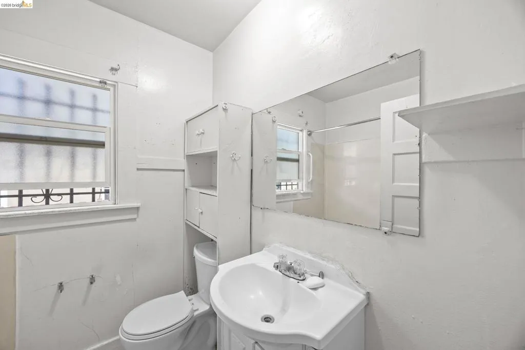 Bathroom featuring a single window, built-in shelving, and wall-mounted mirror