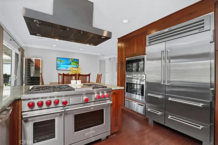 Premium appliances include a built-in Sub-Zero refrigerator, Wolf dual-fuel professional range, double ovens, and custom cabinetry with exceptional storage.