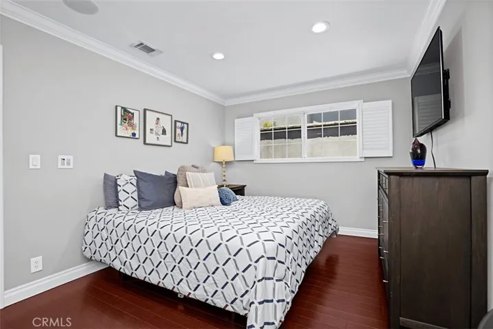 Another view of the secondary bedroom showcasing its comfortable layout and  abundant natural light.