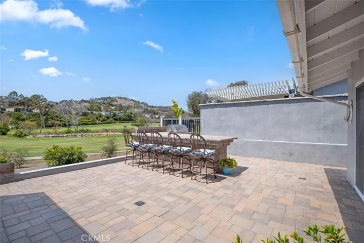 Built-in BBQ with oversized bar seating creates the perfect gathering place for casual meals, celebrations, and sunset evenings overlooking the fairways.