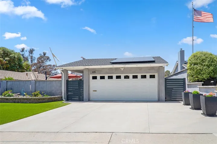 Spacious driveway, attached two-car garage, and low-maintenance landscaping.