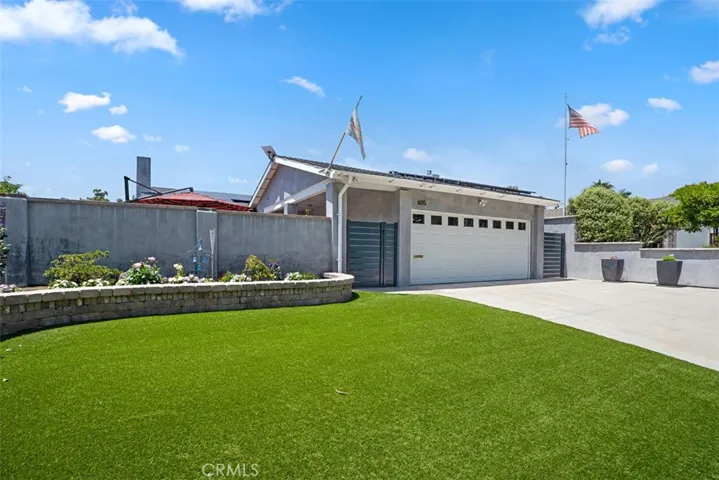 Thoughtfully designed front yard with artificial turf, raised planters, and timeless coastal charm.