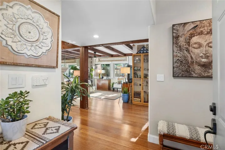 The moment you step through the front door, rich wood floors and architectural beams set the tone for the home beyond.