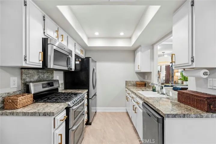 Bright kitchen with granite countertops, brand new kitchen flooring, stainless steel appliances including a double oven, and  abundant cabinetry.