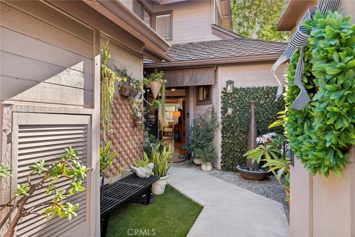 Private gated courtyard welcomes guests with lush landscaping and a warm, inviting entry.