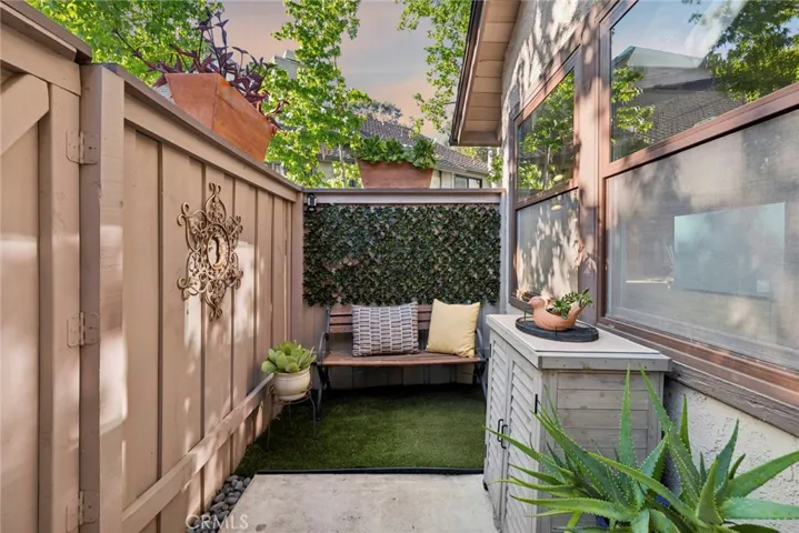 A tucked-away seating nook creates the perfect spot for morning coffee, reading, or a quiet moment beneath the trees.