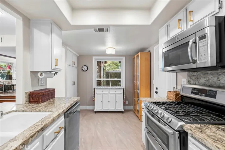 Updated kitchen with granite countertops, stainless steel appliances, recessed lighting, and abundant cabinetry