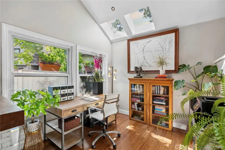 Light-filled flex space with skylights, vaulted ceilings, a cozy fireplace, and views of the back patio.  ideal as a home office, reading room, or creative studio.